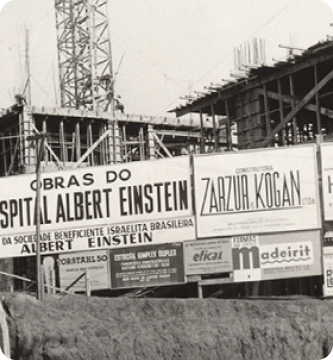 Foto histórica da construção do Einstein, mostra o prédio em estrutura inicial, representa um marco na memória institucional e o compromisso com a excelência em saúde desde o início.