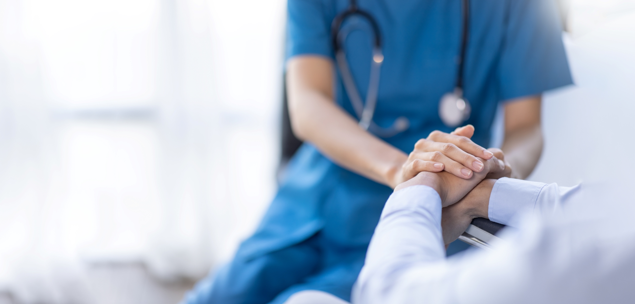 Profissional da saúde segura a mão de um paciente, representa o compromisso institucional com a qualidade, segurança e atuação no SUS, promovendo um atendimento humanizado e eficaz para todos.