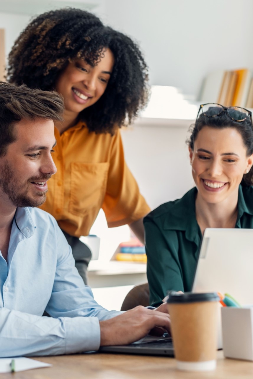 Grupo de pessoas trabalhando em equipe em um escritório, com laptop e copo de café sobre a mesa. Grupo de pessoas trabalhando em equipe em um escritório, com laptop e copo de café sobre a mesa.